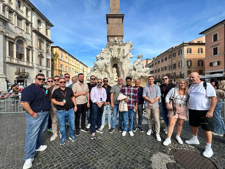 Group photo of Snom distributors in front of a fountain in Rome