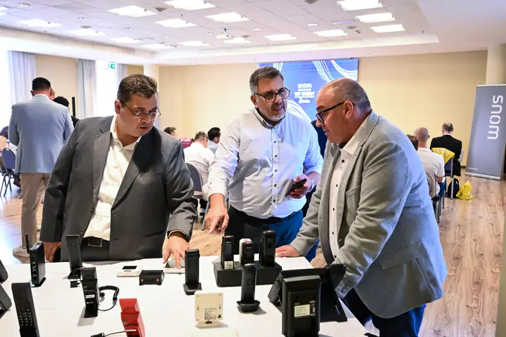 Distributors examining Snom IP phones at a product demo table at the Snom VIP Distributor Event 2026