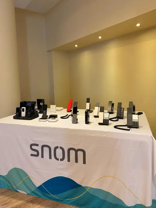 Snom IP phones, DECT handsets and accessories displayed on a Snom-branded table