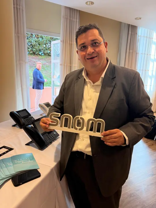Cohesive Technologies representative holding the Snom logo at the Snom VIP Distributor Event 2026