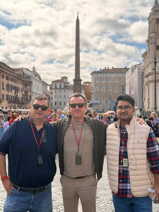 Three attendees in a Rome piazza in front of an ancient obelisk